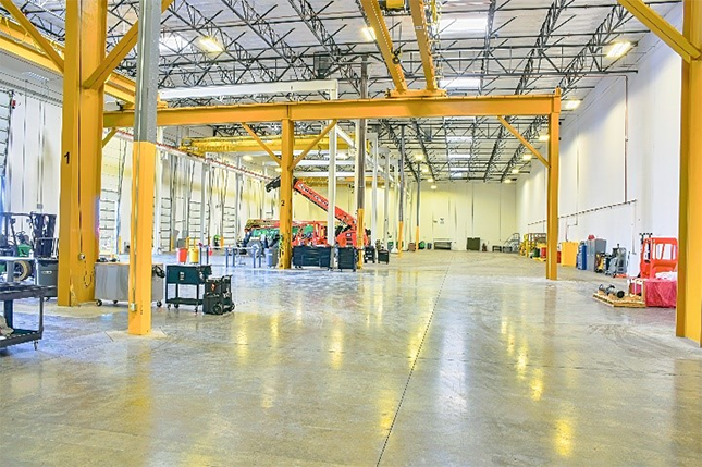 A large warehouse with yellow beams  Description automatically generated